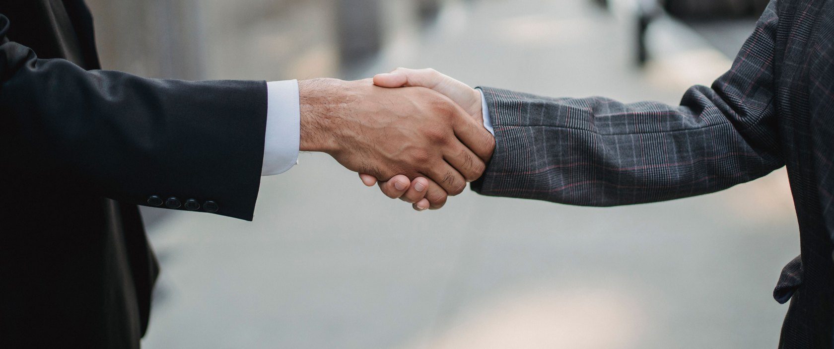 A handshake between two partners on a city street